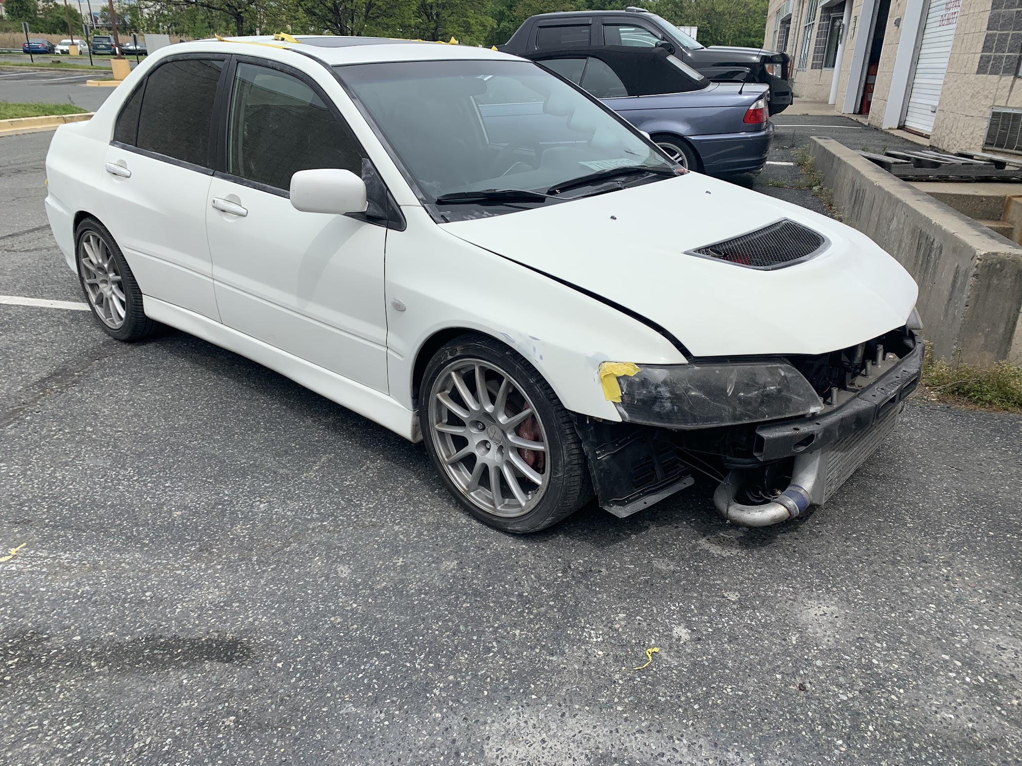 White car with its front bumper removed.